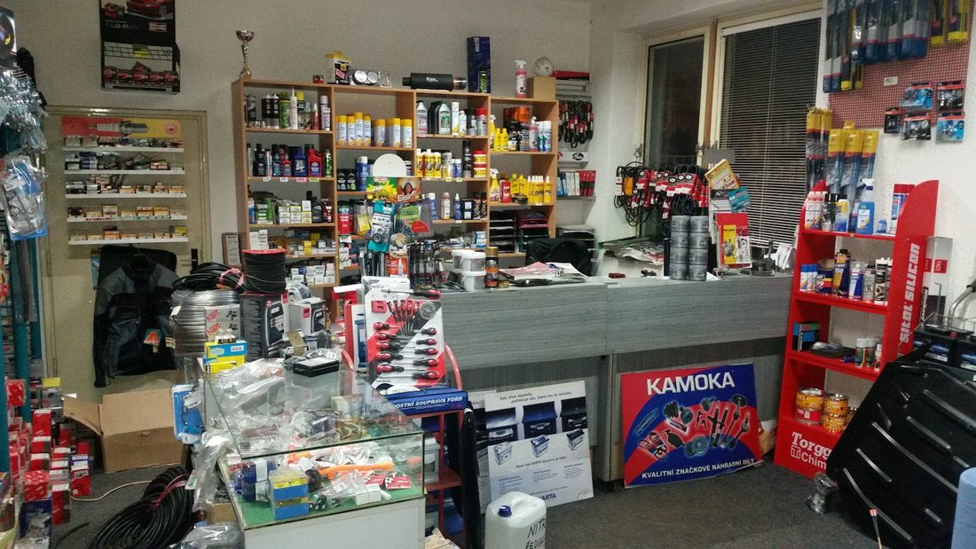 Prodejna autodílů s pultem a regály plnými zboží